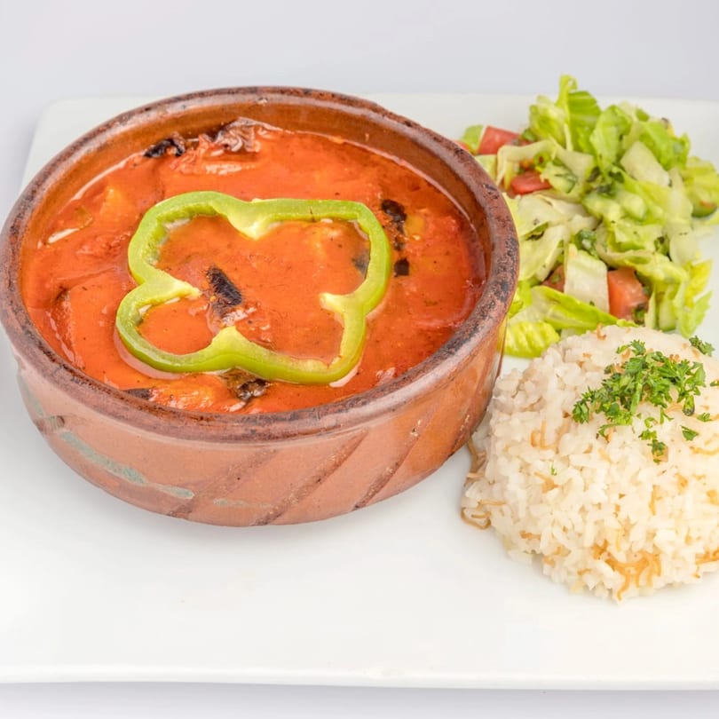 Middle-Eastern tagine with tomato sauce and green bell pepper, served with rice and salad.