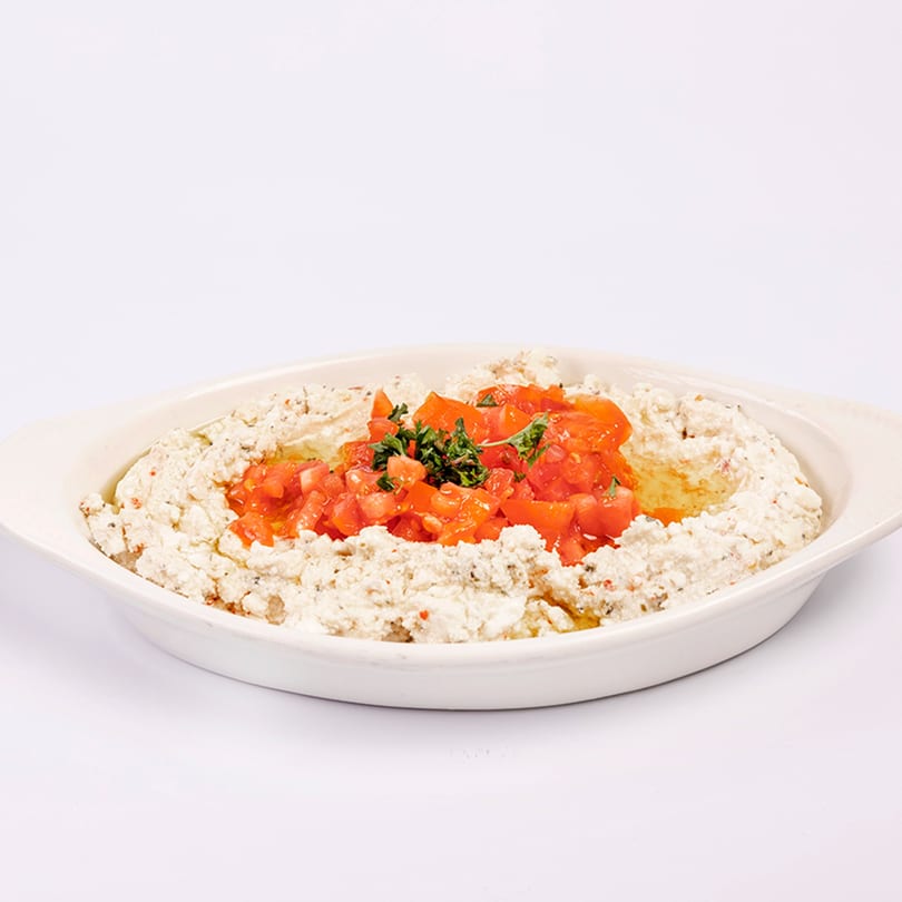 Middle-Eastern Kenz Cairo Restaurant's creamy white dip topped with diced red tomatoes and green herbs.